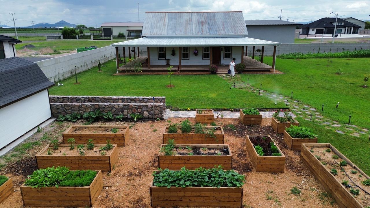 Aerial view of the house front and kitchen garden with someone walking the path