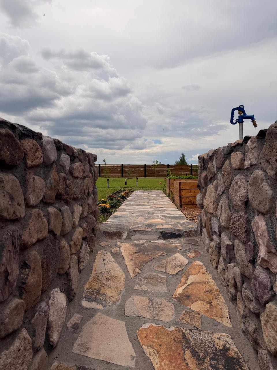 Flagstone path leading between stone walls into the garden