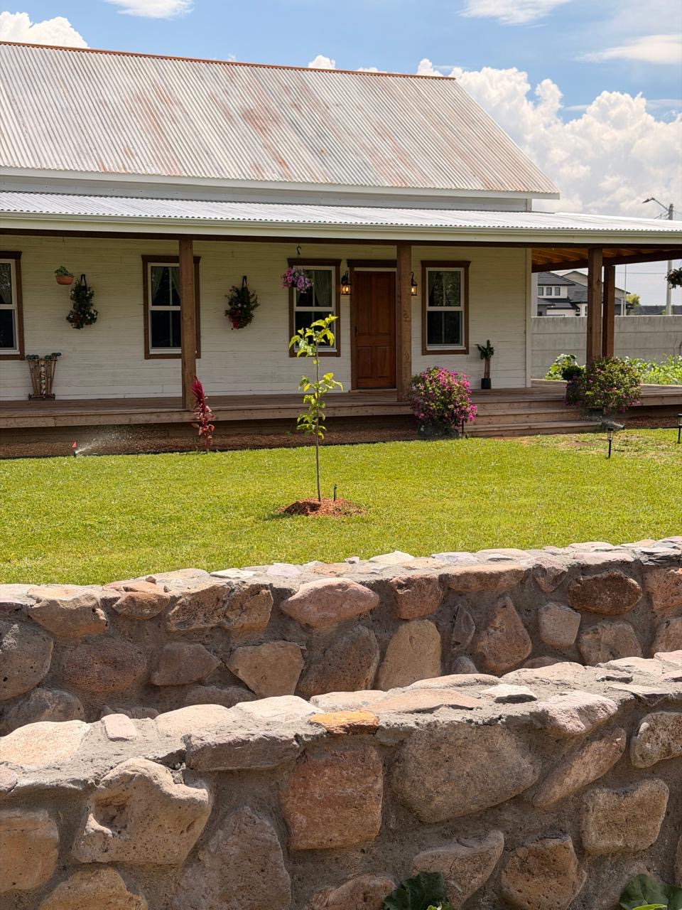Front porch with solid wood door, iron lanterns and cedar-trimmed windows
