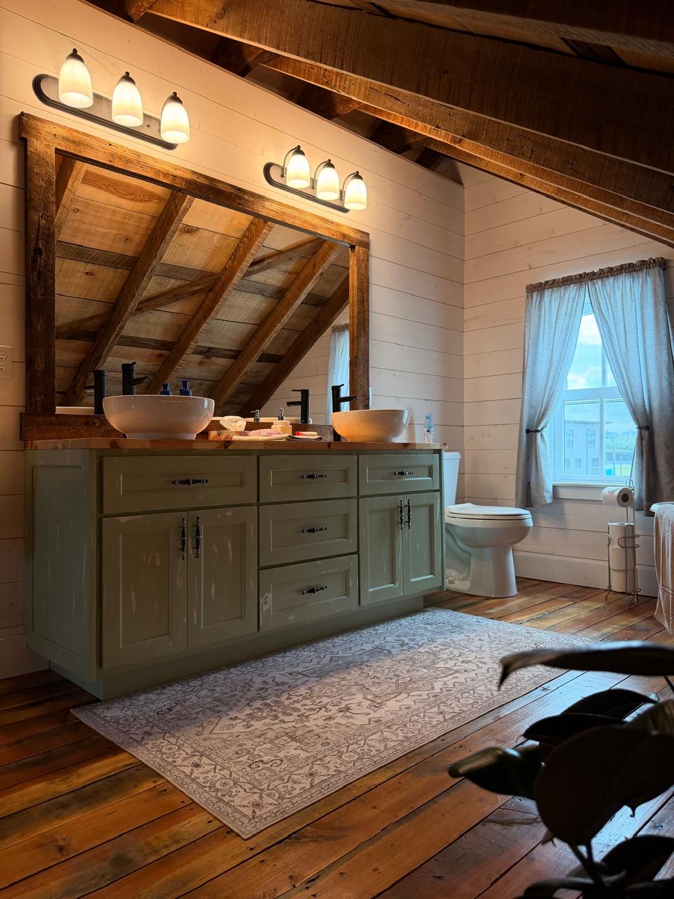 Attic bath with a sage-green vanity, double vessel sinks and exposed beams