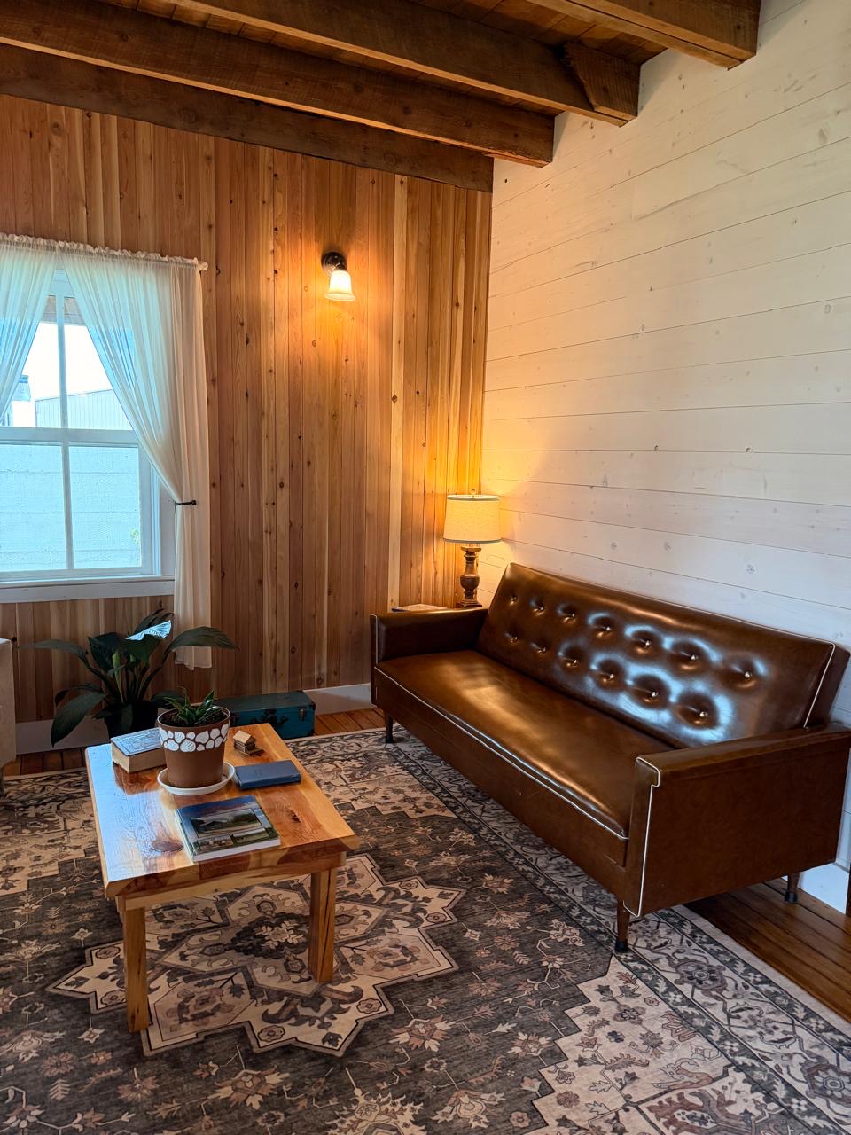 Sitting room with a leather sofa against a cedar plank wall