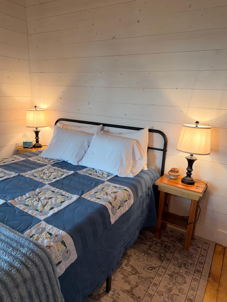 Bedroom with an iron bed, heart-appliqué quilt and matching bedside lamps