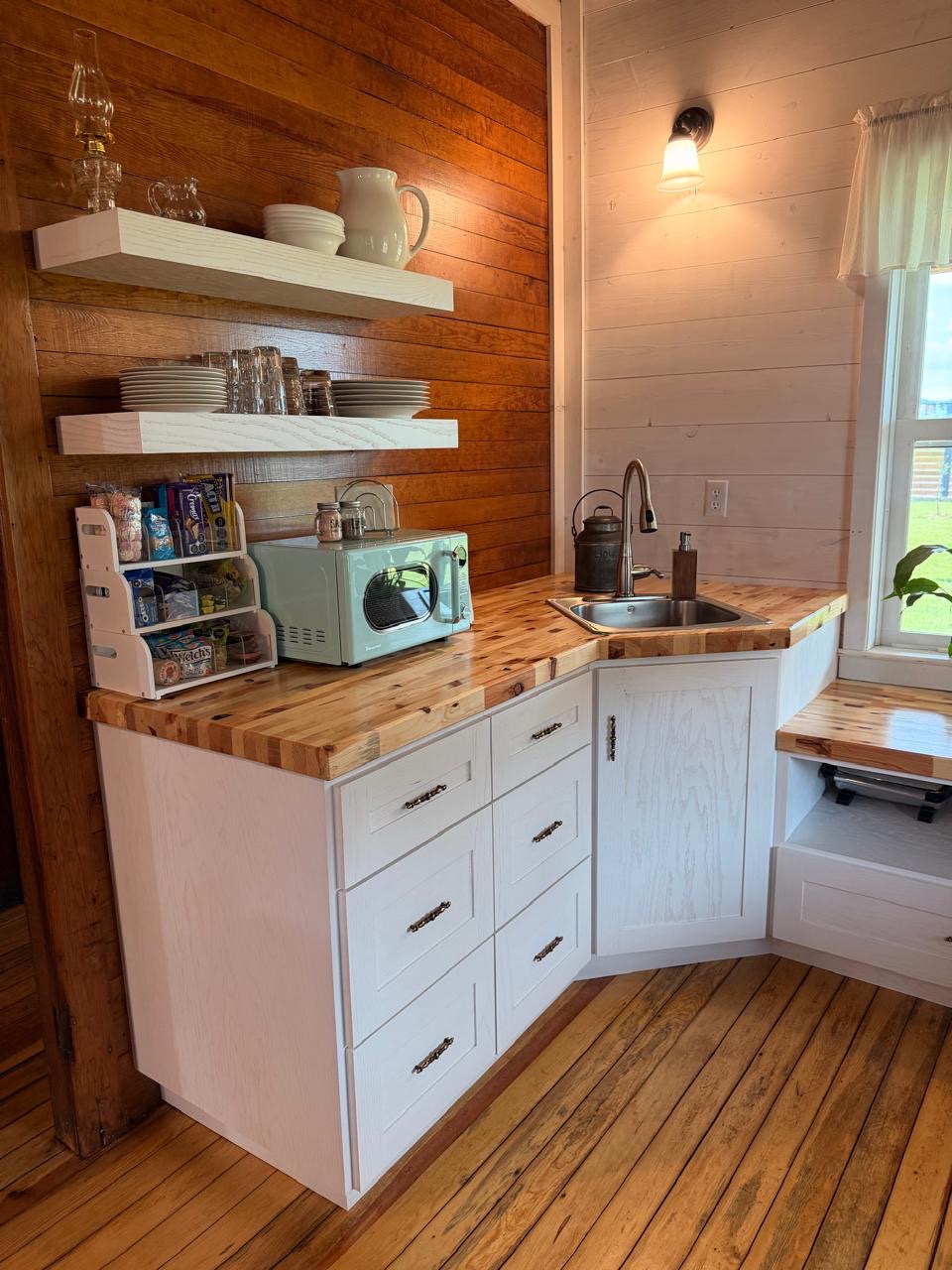 Kitchen with butcher-block counters, white cabinets and open shelving