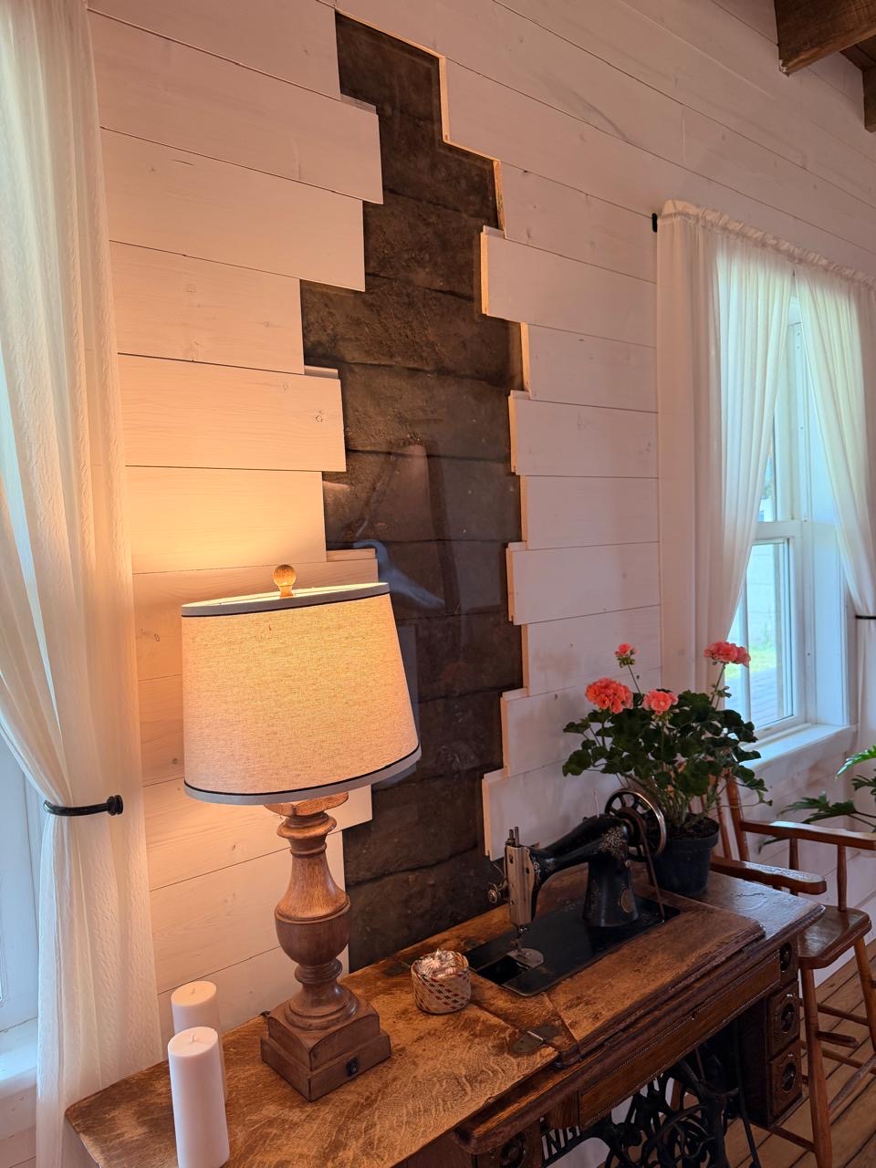 Exposed original chimney breast framed by whitewashed plank walls